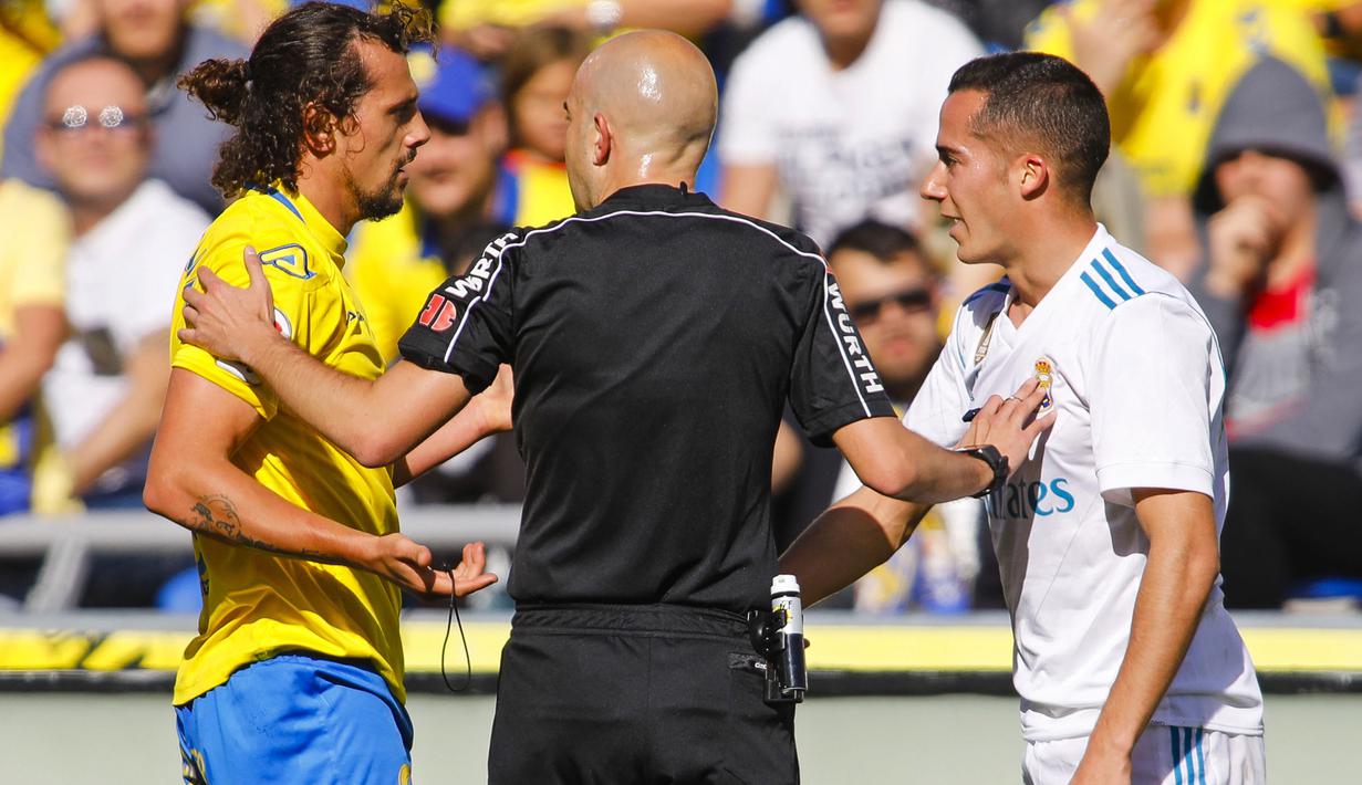 Wasit melerai pemain Las Palmas, Matias Aguirregaray (kiri) dan pemain Real Madrid, Lucas Vazquez pada lanjutan La Liga Santander di Gran Canaria stadium, Canary island, (31/3/2018). Madrid menang 3-0. (AP/Lucas de Leon)