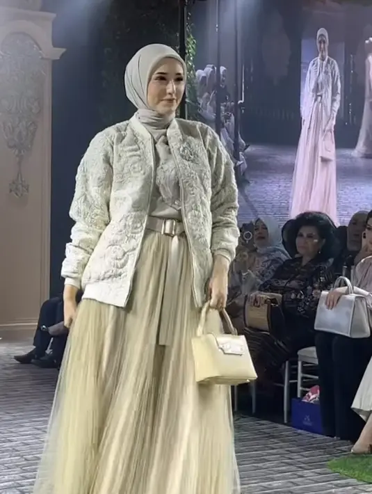 Adelia Pasha tampil dengan bomber jaket dengan motif 3D bunga mawar warna silver serasi dengan kerudungnya, dipadukan rok tulle panjang warna kuning serasi dengan tasnya. [@hapsariannisa29]
