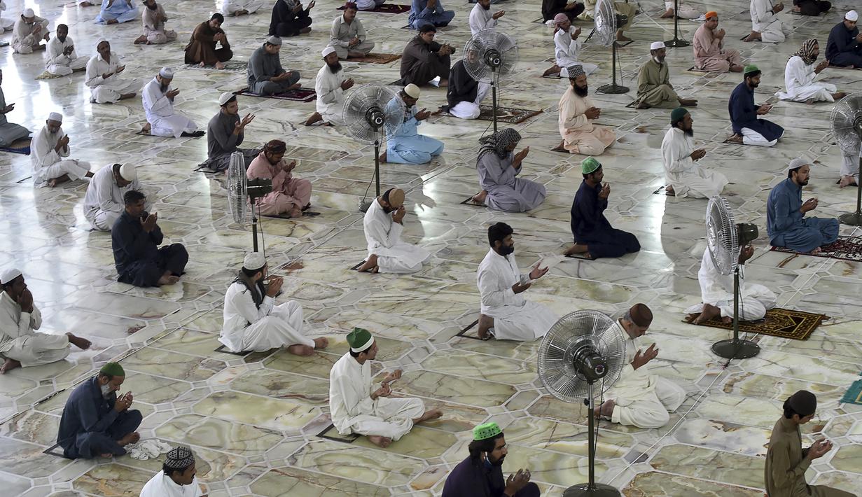 Umat muslim menerapkan jaga jarak aman atau physical distancing saat melaksanakan salat Jumat berjemaah selama Ramadan di Masjid Data Darbar, Lahore, Pakistan, Jumat (1/5/2020). Umat muslim dunia melaksanakan Ramadan tahun ini di tengah pandemi COVID-19. (ARIF ALI/AFP)