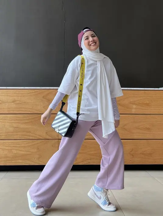 <p>Tya Ariestya mengenakan oversize kaos putih. Ia memadukannya dengan manset bermotif warna ungu serasi dengan celananya. credit: (@tya_ariestya)</p>