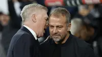 Pelatih Real Madrid, Carlo Ancelotti dan pelatih Barcelona, Hansi Flick berinteraksi dalam laga El Clasico di Estadio Santiago Bernabeu, Senin (27/10/2024) dini hari WIB. (AFP/Oscar Del Pozo)