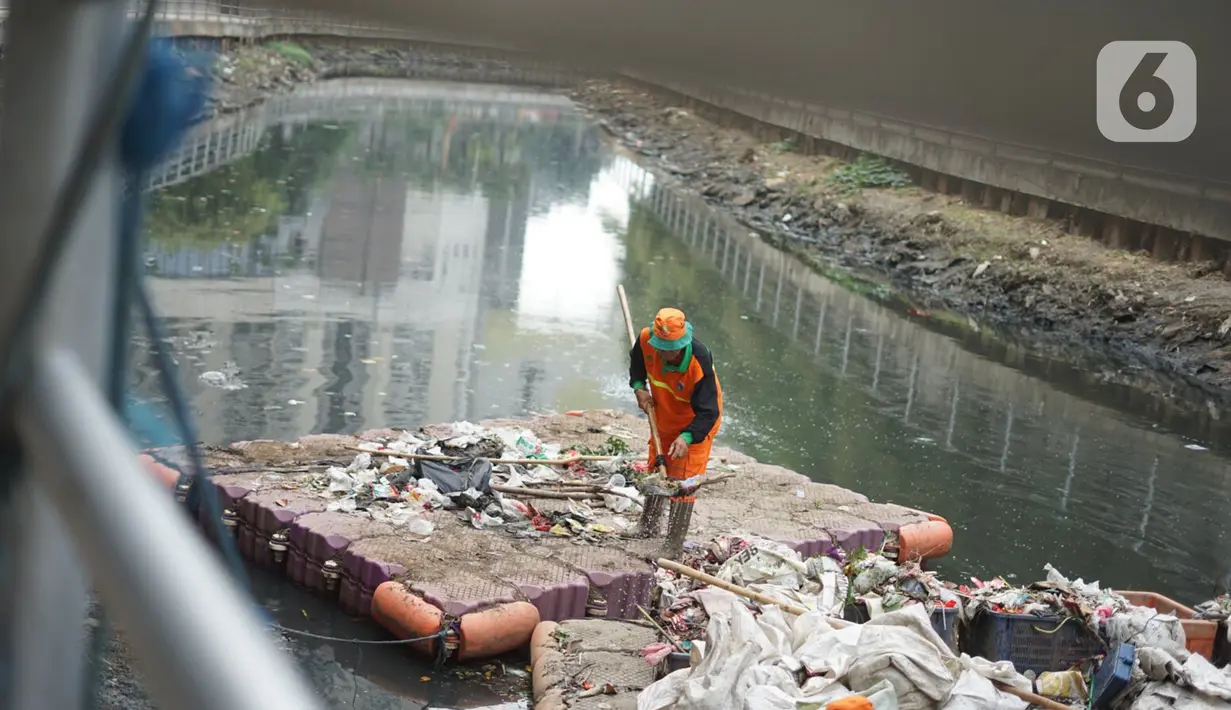 Petugas membersihkan sampah di sepanjang Kali Taman Anggrek, Jakarta, Rabu (8/7/2020). Banyaknya limbah menyebabkan Kali Taman Anggrek menjadi berwarna hitam dan berbau tidak sedap meskipun dibersihkan setiap hari. (Liputan6.com/Immanuel Antonius)