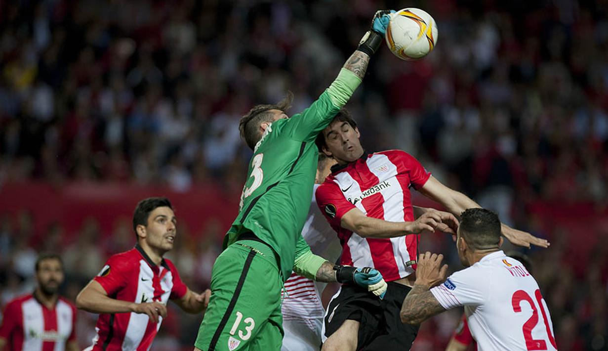 4. Kiper Athletic Bilbao, Iago Herrerin, menepis bola saat laga Liga Europa melawan Sevilla di Stadion Ramon Sanchez Pizjuan, Spanyol, Kamis (14/4/2016). Sevilla lolos ke semifinal berkat menang adu penalti. (AFP/Jorge Guerrero)