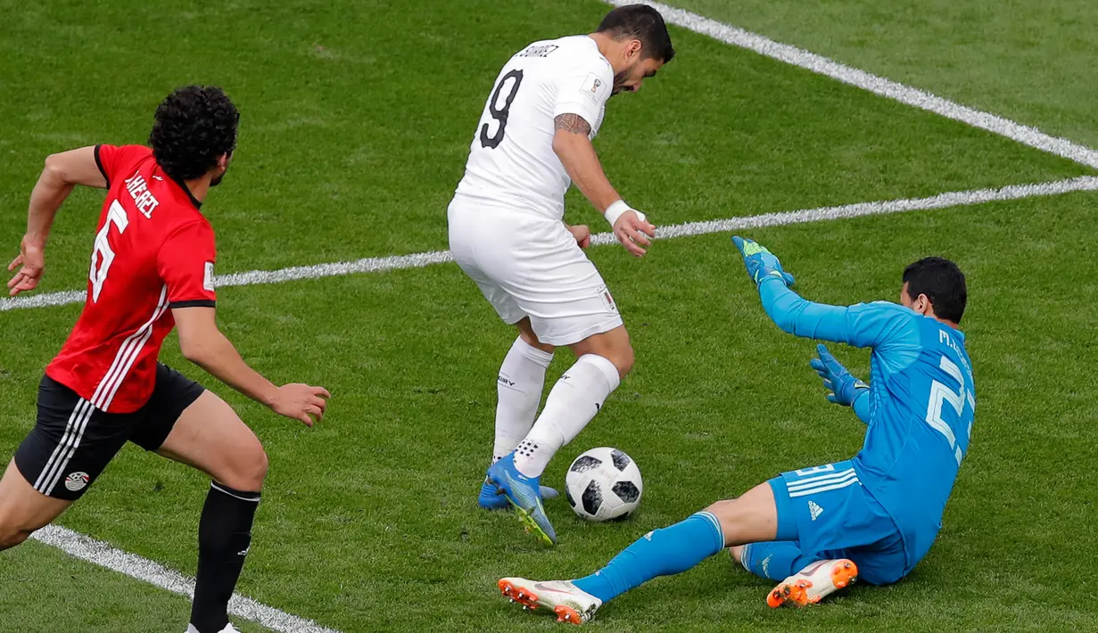 Kiper Mesir Mohamed Elshenawy berusaha menghalau bola yang dibawa Penyerang Uruguay Luis Suarez saat bertanding pada grup A Piala Dunia 2018 di Yekaterinburg Arena, Rusia, (15/6). Uruguay menang dramatis atas Mesir 1-0. (AP Photo / Vadim Ghirda)