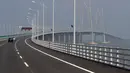 Sebuah mobil melintasi jembatan Hong Kong-Zhuhai-Macau di kota Zhuhai, China selatan, Rabu (28/3). Jembatan laut terpanjang di dunia itu dibangun dengan anggaran senilai 12 miliar pound sterling atau sekitar Rp 218,5 triliun. (AP Photo/Kin Cheung)