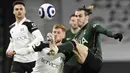 Penyerang Tottenham Hotspur, Gareth Bale, berebut bola dengan pemain Fulham, Harrison Reed, pada laga Liga Inggris di Stadion Craven Cottage, Kamis (4/3/2021). Tottenham Hotspur menang dengan skor 1-0. (Neil Hall/Pool via AP)