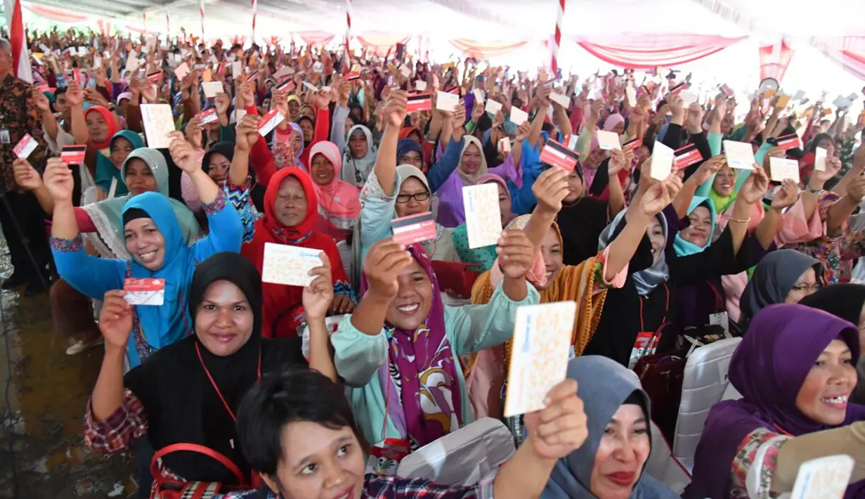 Warga menunjukkan KIP dan PKH saat penyerahan di SMA Negeri 1 Palembang, Sumatra Selatan (22/1). Dimulai sejak tahun 2014, penerima manfaat Kartu Indonesia Pintar (KIP) semakin diperluas. (Liputan6.com/Pool/Biro Setpres)