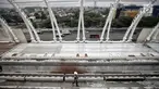 Petugas keamanan melintas di proyek pembangunan Light Rail Transit (LRT) Jabodebek di Stasiun LRT TMII, Jakarta, Senin (14/1). Progres pembangunan Stasiun LRT TMII sudah mencapai 40%. (Liputan6.com/Faizal Fanani)