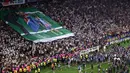 Suporter PSG membentangkan poster bergambar Luis Enrique dan mendiang putrinya, Xana setelah laga final Liga Champions 2024/2025 melawan Inter Milan di Allianz Arena, Munchen, Jerman, Minggu (01/06/2025) dini hari WIB. (AFP Kirill Kudryavtsev)