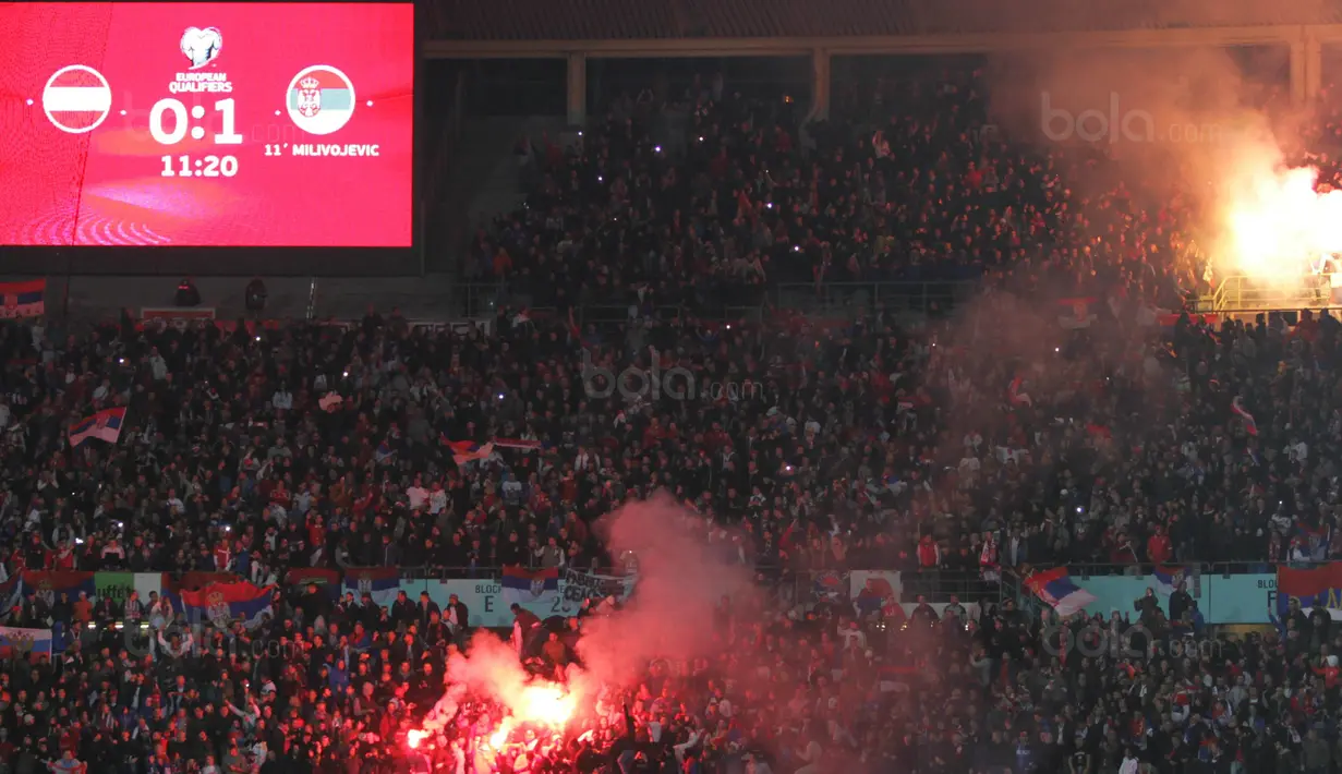 Suporter Serbia menyalakan flare saat mendukung negaranya melawan Austria pada laga kualifikasi Piala Dunia 2018 di Stadion Ernst Happe, Wina, Jumat (6/10/2017). Austria menang 3-2 atas Serbia. (Bola.com/Reza Khomaini)