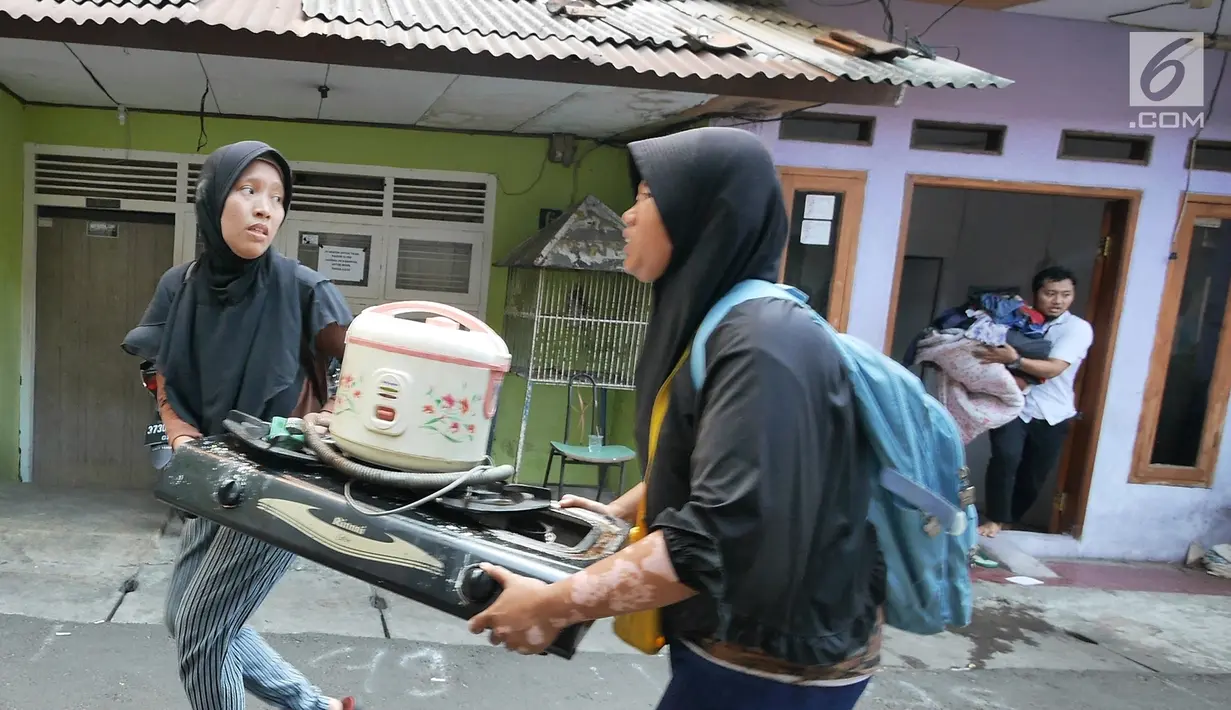 Warga berusaha menyelamatkan harta benda mereka ketika kebakaran melanda permukiman padat penduduk di Manggarai, Jakarta, Rabu (10/7/2019). Belum diketahui pasti penyebab api membakar pemukiman warga tersebut. (Liputan6.com/Herman Zakharia)