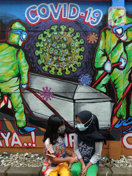 Anak-anak berbincang di depan mural bertema COVID-19 di kawasan Tanah Tinggi, Tangerang, Banten, Rabu (20/1/2020). Kegiatan ini dalam rangka mensosialisasikan bahaya penyebaran COVID-19 kepada warga pengguna jalan umum. (merdeka.com/Arie Basuki)