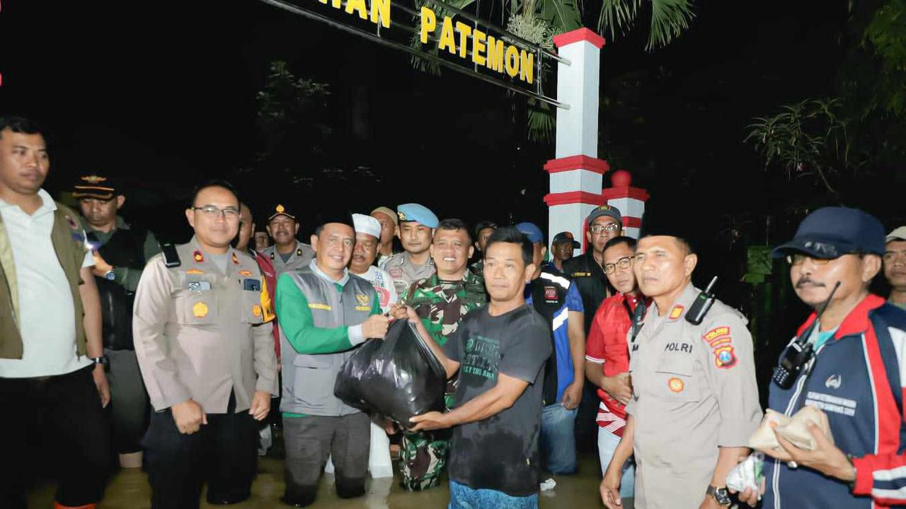 Penjabat (Pj) Bupati Pamekasan Masrukin membagikan bantuan untuk korban banjir. (Istimewa)