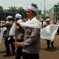 Personel Brimob yang tergabung dalam Pasukan Dzikir Asmaul Husna mengenakan sorban bersiap menjalankan salat di depan Gedung MPR/DPR, Senayan, Jakarta, Selasa (24/10). (Liputan6.com/JohanTallo)