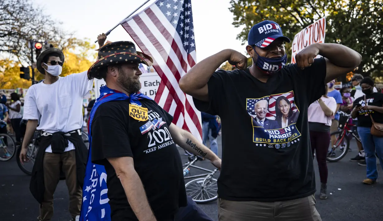 Seorang pendukung Presiden Donald Trump (kiri) dan seorang pendukung mantan Wakil Presiden Joe Biden (kanan) menari bersama saat yang lain merayakan hasil Pilpres Amerika Serikat di Black Lives Matter Plaza, dekat Gedung Putih di Washington pada Minggu (8/11/2020). (Samuel Corum/Getty Images/AFP)