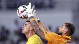 Pemain Al Nassr, Cristiano Ronaldo (kiri), berebut bola di udara dengan penjaga gawang PSG, Gianluigi Donnarumma dalam pertandingan uji coba yang berlangsung di Nagai Stadium, Osaka, Selasa (25/7/2023). (AFP/Paul Miller)