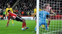 Striker Sheffield United Lys Mousset (kiri) mencetak gol ke gawang Arsenal yang dijaga kiper Jerman Bernd Leno pada pertandingan Liga Inggris di Bramall Lane, Sheffield, Inggris, Senin (21/10/2019). Sheffield United menang1-0. (AP Photo/Rui Vieira)