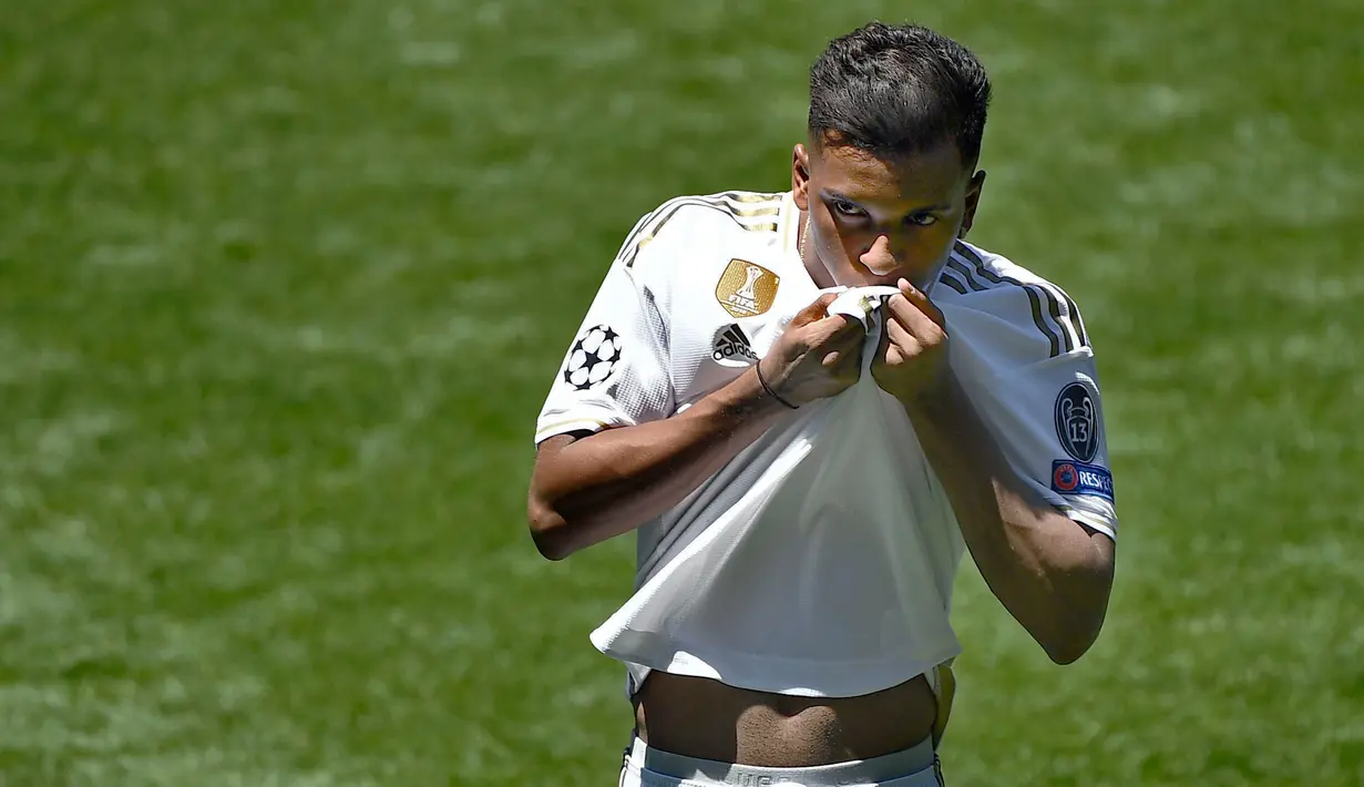 Penyerang Real Madrid Rodrygo Goes mencium jersey barunya saat dirinya diperkenalkan secara resmi di Stadion Santiago Bernabeu, Madrid, Spanyol, Selasa (18/6/2019). Pemain asal Brasil tersebut secara resmi telah bergabung dengan Real Madrid. (OSCAR DEL POZO/AFP)