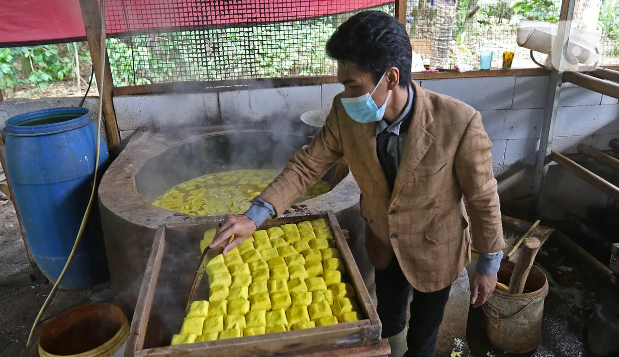 Pekerja memproduksi tahu dengan pakain seperti pekerja kantoran di daerah Sukaraja, Bogor, Senin (14/12/2020). Ide ini dilakukan untuk menunjukkan bahwa pekerja industri rumahan juga bisa bekerja dengan rapih dan bersih. (Liputan6.com/Herman Zakharia)