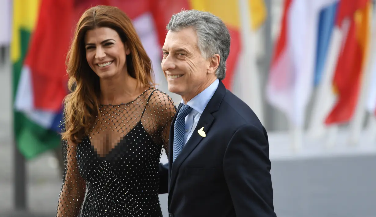 Presiden Argentinia Mauricio Macri dan istrinya Juliana Awada tersenyum saat tiba menghadiri KTT G20 di aula Elbphilharmonie di Hamburg, Jerman, (7/7). Sejumlah pemimpin negara berkumpul dalam KTT G20 pada 7-8 Juli 2017. (AFP Photo/Patrick Stollarz)