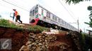 Pekerja meletakkan batuan untuk memperkuat struktur tanah yang longsor dekat rel KRL di sekitar Kampung Pabuaran, Bogor, Rabu (25/11/2015). Sebelumnya, Selasa (24/11) tanah di sekitar rel KM 38 dan 39 mengalami longsor. (Liputan6.com/Helmi Fithriansyah)
