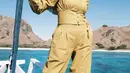 Liburan di pantai bisa mengenakan warna cerah seperti Anselma. Ia mengenakan atasan crop dengan aksen obi dipadukan celana high waist warna kuning kunyit. Dipadukan kerudung coklat serta syal colorfull di atas kerudungnya. Tak lupa kacamata hitam.  [@ansellmaputri]