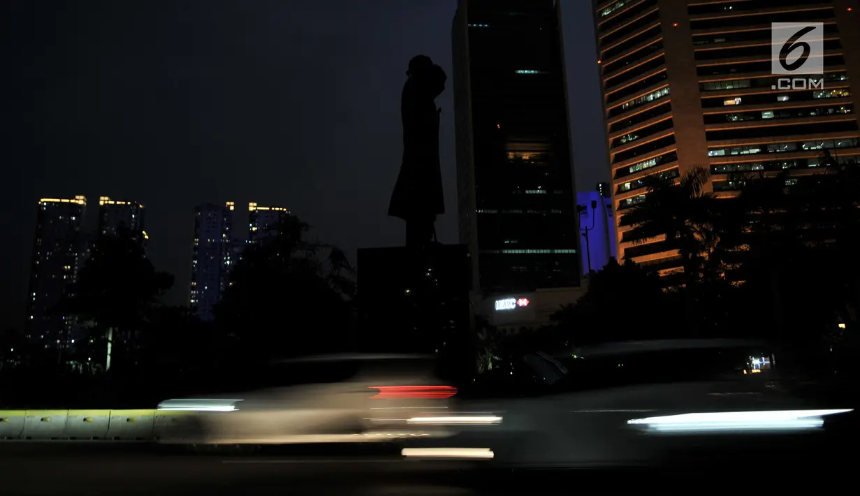 Kendaraan melintasi Patung Jenderal Sudirman saat listrik padam di kawasan Jakarta, Minggu (4/8/2019). Pemadaman listrik serentak yang terjadi sejak Minggu siang mengubah suasana malam di ibu kota menjadi gelap gulita. (merdeka.com/Iqbal S. Nugroho)