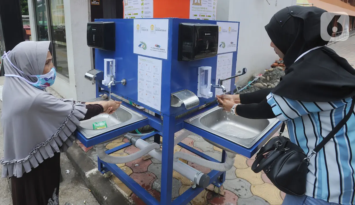 Warga menggunakan fasilitas tempat cuci tangan atau wastafel portabel di Pasar Bogor, Jalan Suryakencana, Kota Bogor, Sabtu (29/3/2020). Wastafel portabel itu sebagai upaya meningkatkan perilaku hidup bersih dan sehat (PHBS) juga mencegah penyebaran pandemi virus Corona. (merdeka.com/Arie Basuki)