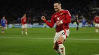Bek Manchester United asal Portugal #20, Diogo Dalot, merayakan golnya setelah memberi umpan kepada gelandang Manchester United asal Portugal #08, Bruno Fernandes, untuk mencetak gol ketiga mereka selama pertandingan Liga Primer Inggris antara Leicester City dan Manchester United di Stadion King Power di Leicester, Inggris bagian tengah pada tanggal 16 Maret 2025. (Adrian Dennis/AFP)