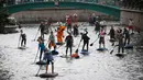 Orang-orang mendayung "paddle board" di sepanjang kanal Griboedov pada festival SUP (Stand Up Paddle)-Surfing di St.Petersburg, Rusia, Minggu (12/8). Dalam paddling, mereka menggerakkan papannya dengan cara mendayung sambil berdiri. (AP/Dmitri Lovetsky)