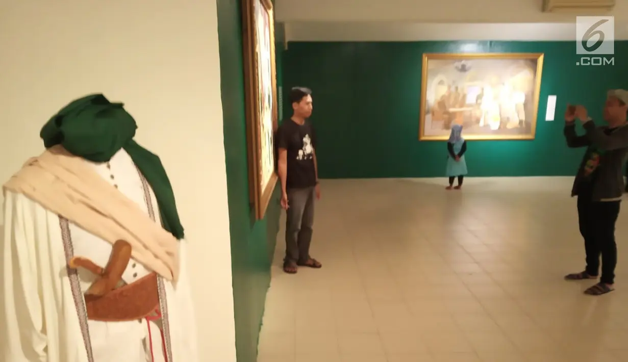 Pengunjung foto di depan lukisan saat pameran gambar Babad Diponegoro di Yogyakarta,  Minggu (10/2). 51 Seniman mengikuti acara pameran ini yang menceritakan perang Jawa Pangeran Diponegoro melawan penjajah Belanda. (Liputan6.com/Gholib)