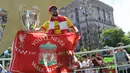 Fans Liverpool berpose dengan trofi Liga Champions yang dipamerkan di Kiev, Ukraina, Kamis (24/5/2018). Fans mulai berdatangan ke kota Kiev untuk menyaksikan laga final Liga Champions antara Liverpool kontra Real Madrid. (AFP/Sergei Supinsky)