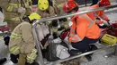 Seorang korban kebakaran sedang menerima pertolongan dari tim medis di Stasiun Tsim Sha Tsui, Hong Kong (10/2). Sedikitnya 17 orang mengalami cedera akibat kebakaran di sebuah kereta bawah tanah Hong Kong ini. (Handout / Apple Daily / AFP)