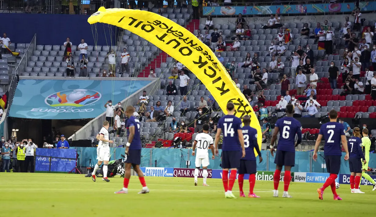 Paraglider Greenpeace mendarat di lapangan sebelum pertandingan Grup F Euro 2020  antara Prancis dan Jerman di Allianz Arena, Munich, Jerman, Selasa (15/6/2021). Sang aktivis langsung diamankan saat mendarat di lapangan. (AP Photo/Matthias Schrader, Pool)