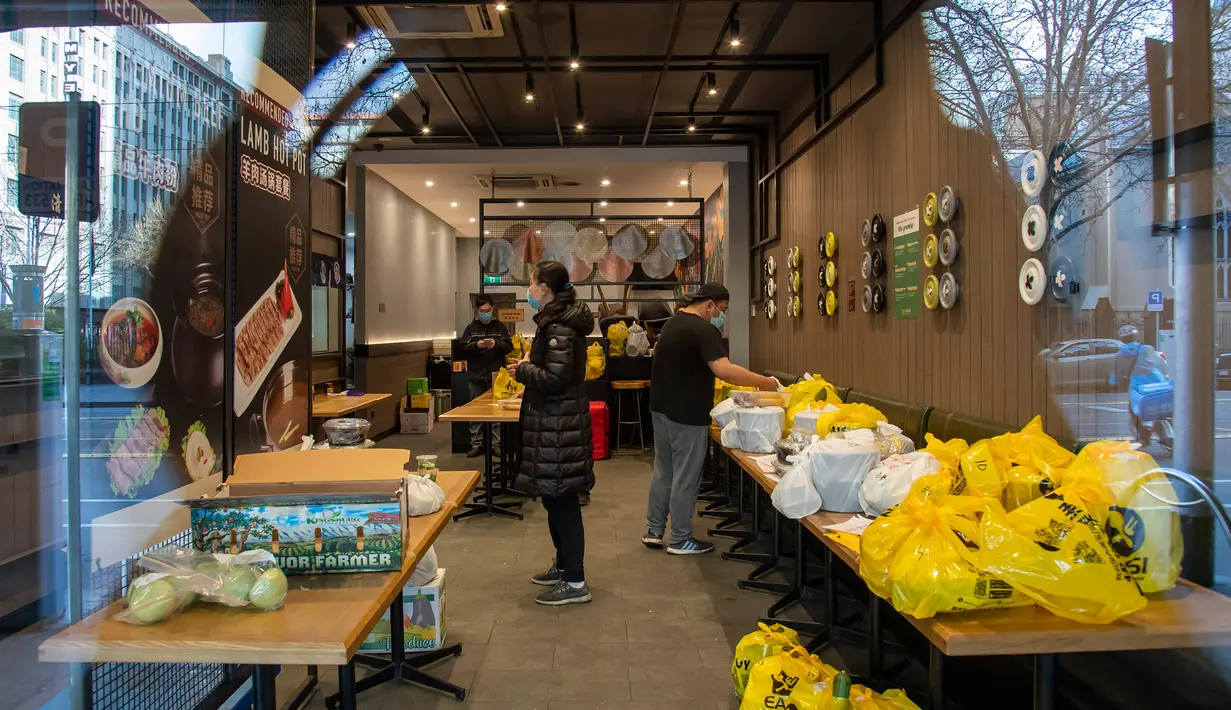 Sebuah restoran menyiapkan pesanan makanan pengiriman selama lockdown atau penguncian wilayah di Melbourne, Kamis (6/8/2020). Negara bagian Victoria, hotspot COVID-19 di Australia, melakukan lockdown dan menutup bisnis ritel sebagai upaya mencegah penyebaran virus corona. (AP Photo/Andy Brownbill)