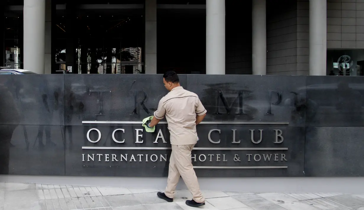 Pekerja membersihkan nama 'Trump' yang telah dicopot dari papan sebuah hotel mewah di Panama, Senin (5/3). Sementara itu, Trump Organisation bersikukuh, pencopotan nama tersebut hanya bersifat sementara dan masih menanti putusan final. (AP/Arnulfo Franco)