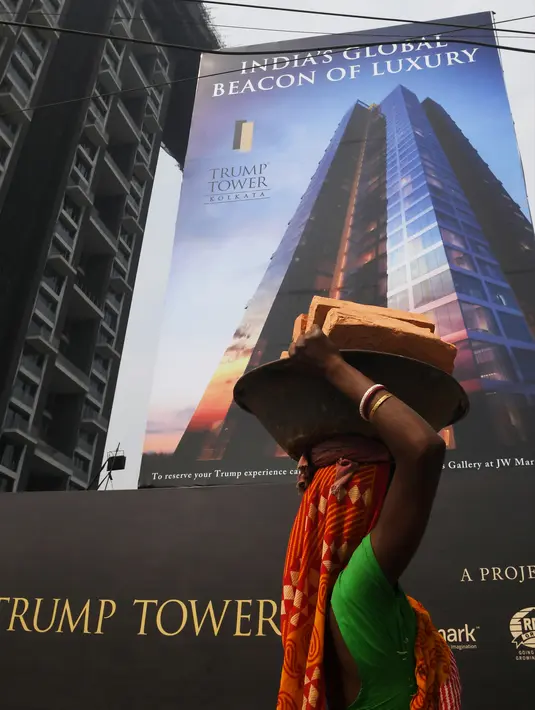 Seorang buruh wanita India mengangkat batu bata untuk pembangunan Trump Tower di Kolkata, India (20/2). Di India keluarga Trump memiliki proyek real estat yang tersebar seperti di Mumbai, pinggiran Gurgaon New Delhi dan Kolkata. (AFP/ Dibyangshu Sarkar)