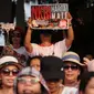 Penonton membawa poster saat hadir dalam Konser Kebangkitan Nasional di Waduk Pluit, Penjaringan, Jakarta Utara, Sabtu (20/5). (Liputan6.com/Gempur M. Surya)