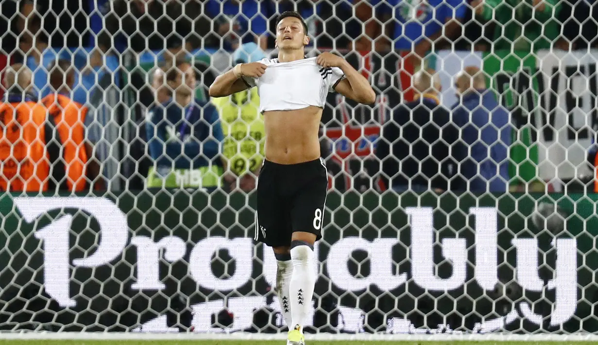 Pemain Jerman, Mesut Ozil tampak kecewa usai gagal mencetak gol lewat penalti ke gawang Italia  pada laga perempat final Piala Eropa 2016 di Stadion Matmut Atlantique, Bordeaux, Minggu (3/7/2016) dini hari WIB. (REUTERS/Kai Pfaffenbach)