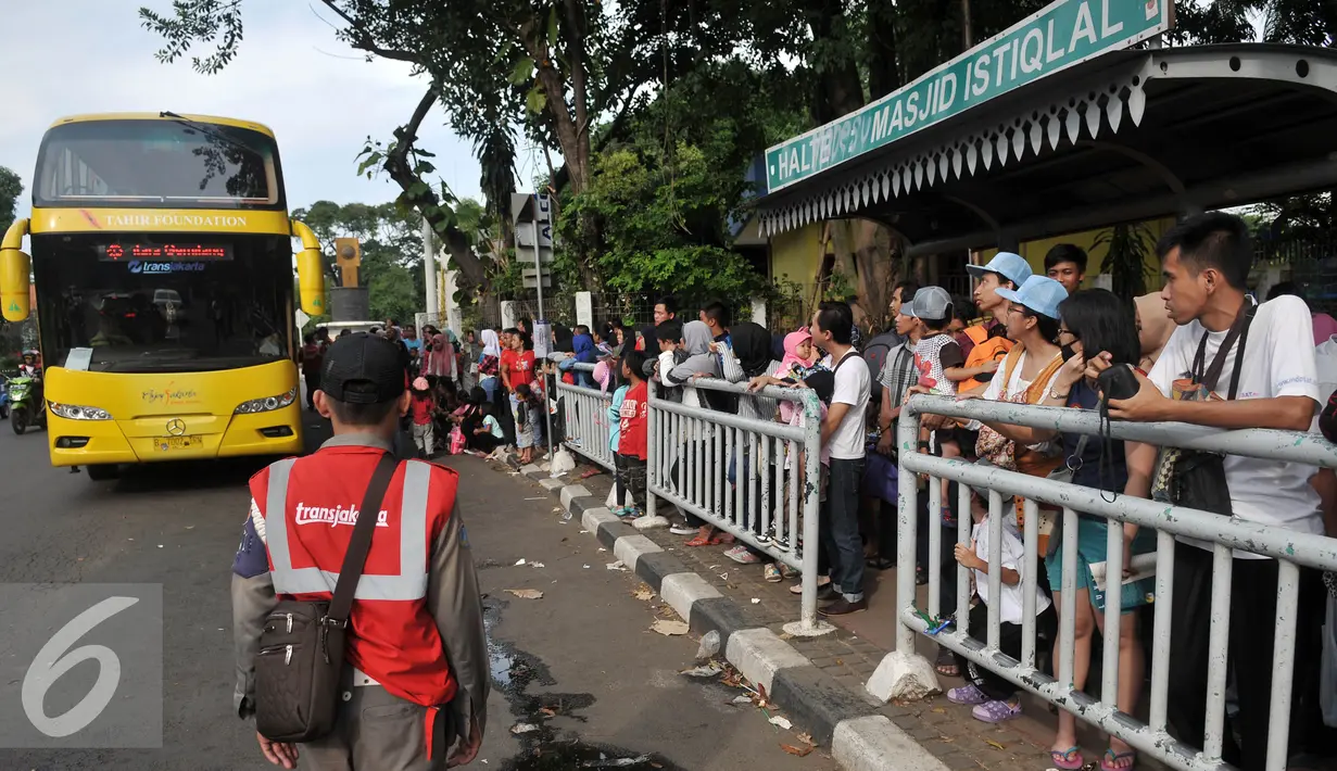 Warga mengantre naik Bus City Tour Jakarta di Jakarta, Sabtu (9/7). Masyarakat Jakarta memanfaatkan libur Lebaran dengan menumpang bus gratis untuk mengunjungi ikon Ibu kota seperti Patung Selamat Datang, Mesjid Istiqlal. (Liputan6.com/Johan Tallo)