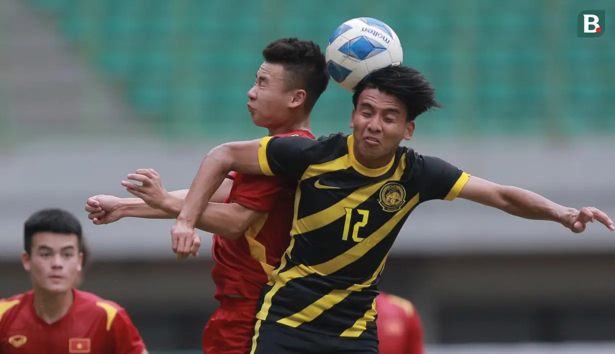 <p>Pemain Timnas Malaysia U-19, Zaid El Basheer Norhisham (kanan) berebut bola dengan pemain Vietnam U-19&nbsp;pada laga semifinal Piala AFF U-19 2022 yang berlangsung di Stadion Patriot Candrabhaga, Bekasi, Rabu (13/07/2022). (Bola.com/M Iqbal Ichsan)</p>