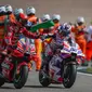 Momen Jorge Martin bersalaman dengan Pecco Bagnaia usai memenangkan balapan MotoGP Jerman di Sirkuit Sachsenring, Jerman hari Minggu (18/06/2023). (Ronny Hartmann / AFP)