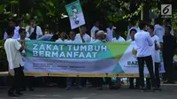 Badan Amil Zakat Nasional (Baznas) melakukan pawai simpatik menyambut Ramadan 1440 Hijriah di Patung Kuda, Jakarta, Jumat (3/5/2019). Dalam aksinya, Baznas menyerukan kewajiban membayar zakat, mengingat Ramadan semakin dekat. (merdeka.com/Imam Buhori)