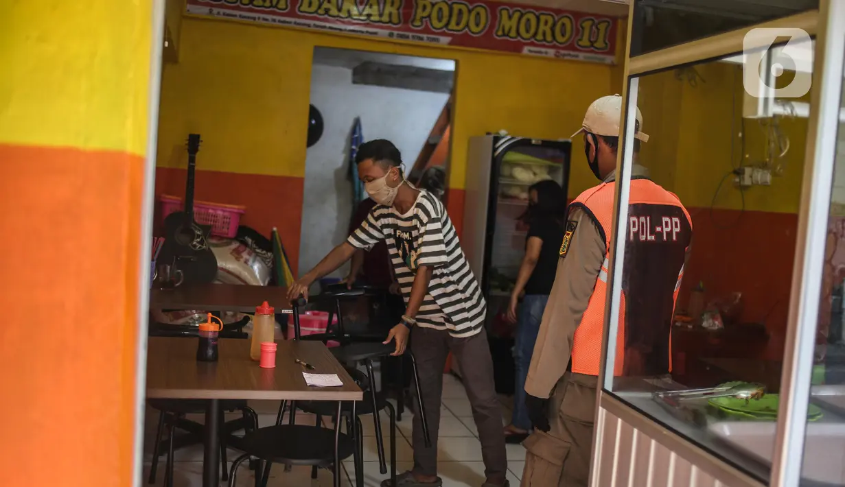 Petugas Satpol PP menertibkan warung makan yang melanggar aturan pembatasan sosial berskala besar (PSBB) di kebon kacang, Jakarta, Senin (1/6/2020). Pelanggaran berupa menerima pelanggan yang makan di warung ditertibkan oleh petugas untuk mencegah penyebaran COVID-19. (Liputan6.com/Faizal Fanani)