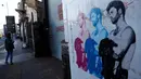 Pejalan kaki mengamati gambar mural musisi asal Inggris, George Michael, di Shoreditch, London timur, 29 Desember 2016. Mural itu diciptakan seorang seniman jalanan Pegasus sebagai penghormatan terhadap mendiang George Michael. (REUTERS/Stefan Wermuth)