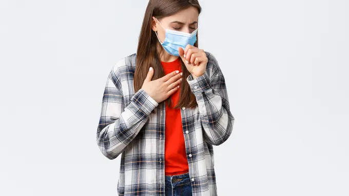 Seorang perempuan yang mengenakan masker terbatuk sambil memegang bagian dadanya (Foto Dok: Freepik/benzoix)