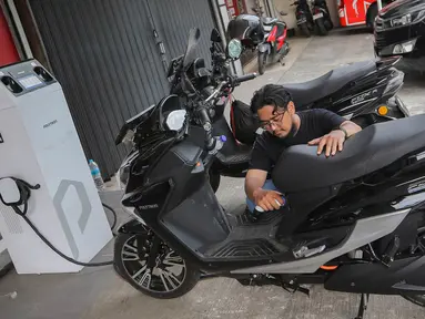 Pengunjung melakukan pengisian energi pada sepeda motor listrik di Jakarta, Jumat  (12/1/2024). (Liputan6.com/Angga Yuniar)