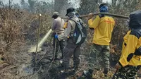 Relawan Karhutla Riau yang sudah dilatih mulai memadamkan kebakaran lahan bersama personel Polda Riau. (Liputan6.com/M Syukur)