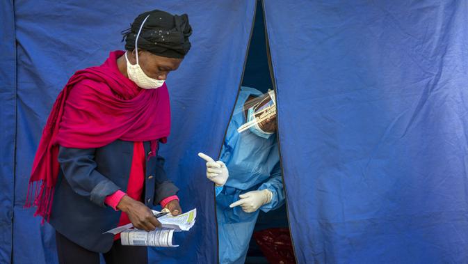 Petugas medis memeriksa daftar orang yang akan dites COVID-19 serta HIV dan TBC di Johannesburg, Afrika Selatan, Kamis (30/4/2020). Afrika Selatan akan mulai mengurangi penerapan lockdown secara bertahap pada 1 Mei, meski kasus COVID-19 yang dikonfirmasi terus meningkat. (AP Photo/Jerome Delay)