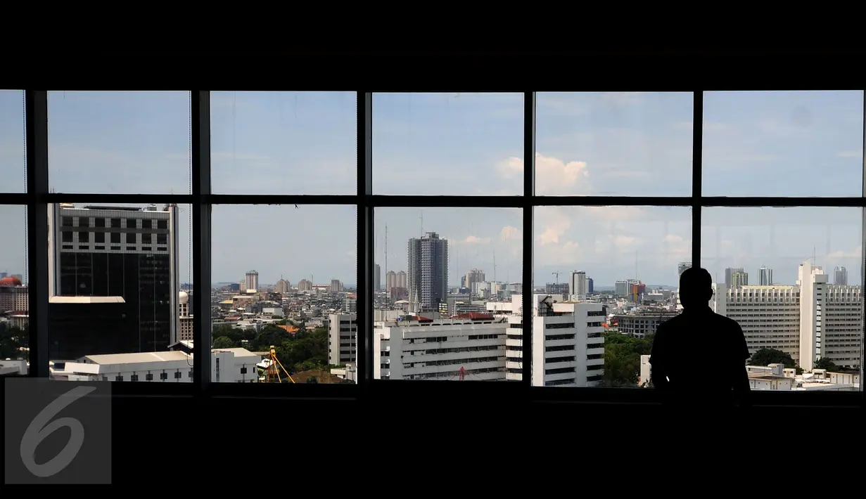 Seseorang mengamati kota Jakarta dari dalam Gedung Mina Bahari IV KPP, Rabu (26/10). Berdasar data CTBUH, pada 2015 lalu Jakarta menjadi kota yang paling banyak memiliki gedung setinggi 200 meter dengan jumlah 7 gedung. (Liputan6.com/Helmi Fithriansyah)